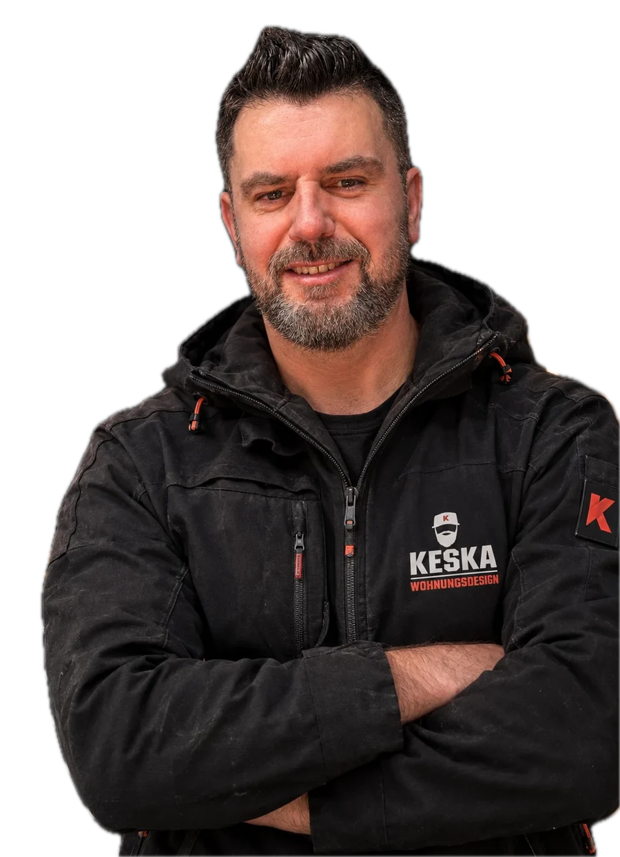 Krzysztof Artur Keska, Inhaber von Keska Wohnungsdesign, in Arbeitsjacke mit Firmenlogo