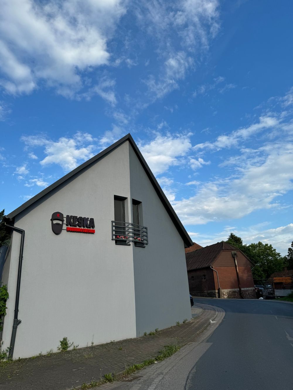 Firmengebäude von Keska Wohnungsdesign mit Logo an der Giebelwand